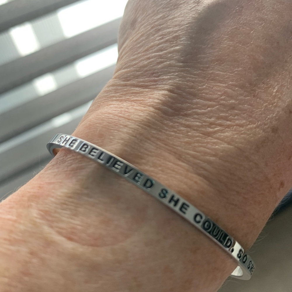 “SHE BELIEVED SHE COULD, SO SHE DID” mantra band. Silver. Black lettering.